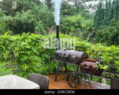 smoking barbecue smoker on a terrace, Germany Stock Photo