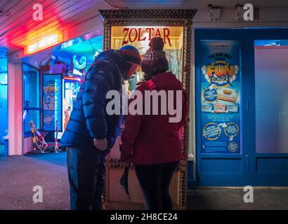 Couple operating a Zoltar fortune teller machine. Stock Photo