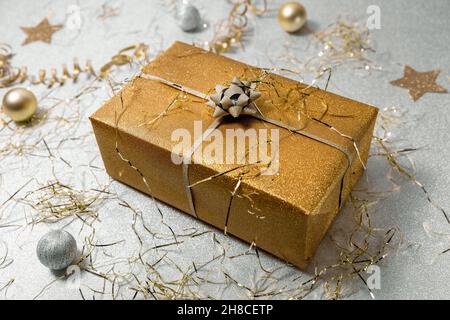 shiny golden gift box on silver glitter background with confetti Stock Photo