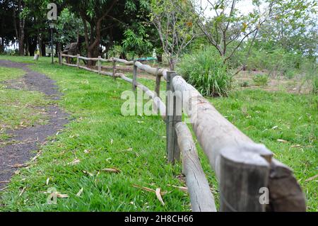 Wooden fence in panoramic view with out of focus foreground and green area with path on the side in a tourist site in the interior of Brazil, South Am Stock Photo