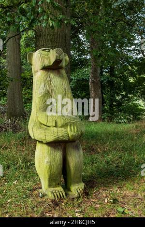 Wooden bear holding a fish, carving on the Allen Coppice sculpture trail, LongMynd House, Church Stretton, Shropshire, England Stock Photo