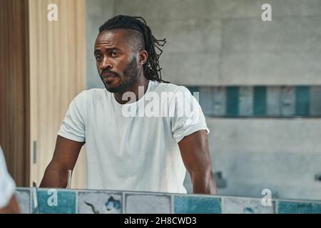 Concentrated man looking at his face in bathroom Stock Photo