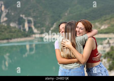 Happy friends hugging and laughing in a lake on summer vacation Stock Photo
