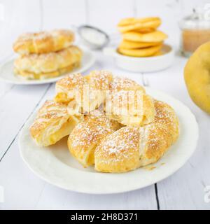Apple rings in puff pastry, with cinnamon and powdered sugar. Stock Photo