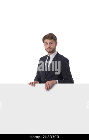 Young serious business man showing blank signboard, isolated over white background Stock Photo