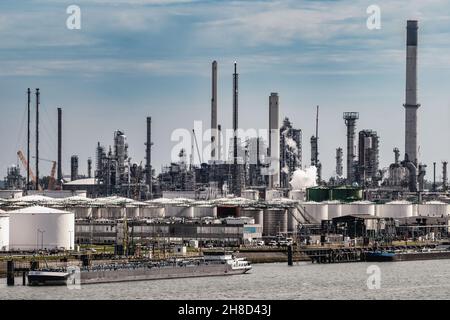 Oil refinery industrial petrochemical plant factory and barges in an industrial shipping port Stock Photo