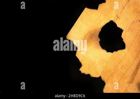 Burned peice of old paper on a black background. Vintage and retro design photo Stock Photo