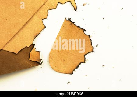 Burnt peice of old paper on a white background. Vintage and retro design Stock Photo