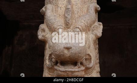 Lion face shaped stone pillar carved in rock. On a blurred background Stock Photo