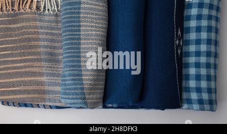 Roll of hand woven shawls, Thai cotton indigo dyed isolated on white background Stock Photo