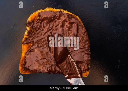 Spreading chocolate cream on toasted bread Stock Photo