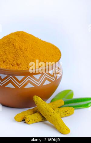 Turmeric Powder, Tumeric rhizome and turmeric powder in bowl isolated on white background, indian spice, healthy seasoning ingredient for vegan cuisin Stock Photo