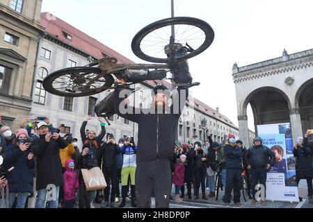 Munich, Germany. 29th Nov, 2021. German extreme athlete Jonas Deichmann lifts his bike into the air at Odeonsplatz at the finish of his triathlon around the world. He cycled the last leg from Portugal to Munich. He started in Munich on 26 September 2020, where he has now completed his journey. Credit: Felix Hörhager/dpa/Ģ����ý Live News Stock Photo