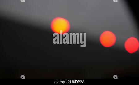 Three defocused red orange lights against grey background with copy space Stock Photo