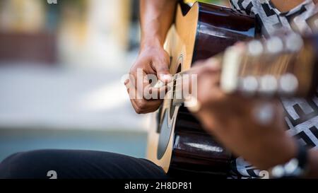 Detail of latin guitar player playing guitar in the street Stock Photo