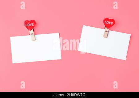White sheets of note with hearts clothespins with text love, on a pink background. The concept of Valentine's Day, declaration of love. Copy space Stock Photo