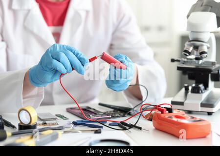 Master repairman checking battery charge using tester closeup Stock Photo