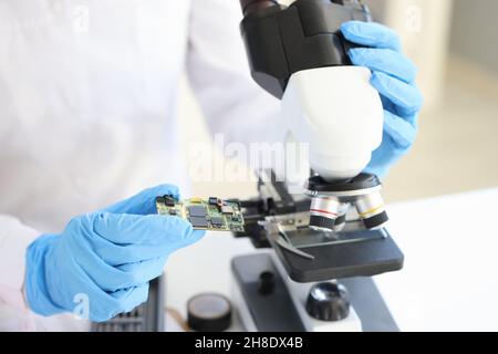 Scientist looking under microscope computer processor closeup Stock Photo