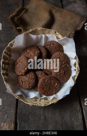 Oven fresh chocolate cookies in a basket. Close up. Stock Photo