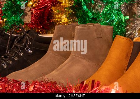 Many leather footwear displayed in a shop window at Christmas Stock Photo