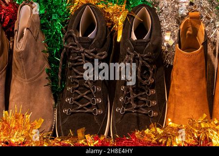 Many leather footwear displayed in a shop window at Christmas Stock Photo