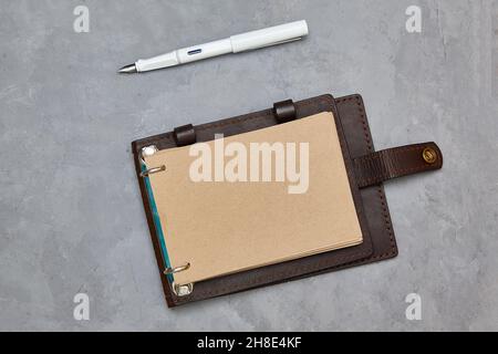 Design concept - Top view open notebook with kraft paper in a leather cover. A fountain pen. Copy space. Background for mockup Stock Photo