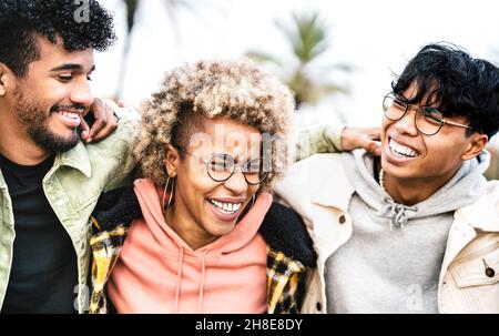 Multicultural friends walking at travel location - Life style concept with happy guys and girls having fun together outdoor - College students Stock Photo