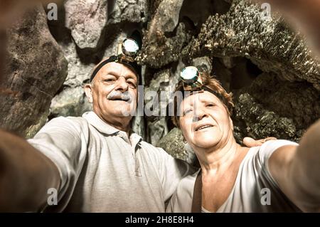 Senior happy couple taking a selfie at the entrance of Tham Phu Kham in Vang Vieng - Adventure travel in Laos and asian destinations Stock Photo