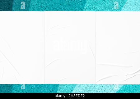 teal mint urban wall with three glued posters Stock Photo