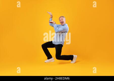 Smiling mature man enjoying music dancing disco Stock Photo