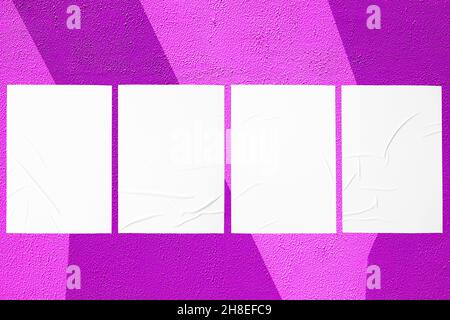 purple urban wall with four glued posters Stock Photo