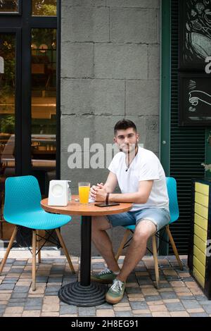 Bearded Armenian man with a white t-shirt sitting in an outdoor cafe Stock Photo