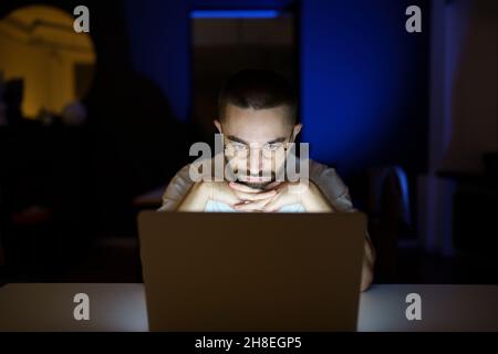 Thoughtful freelancer journalist or writer late at night work on laptop on project within deadline Stock Photo