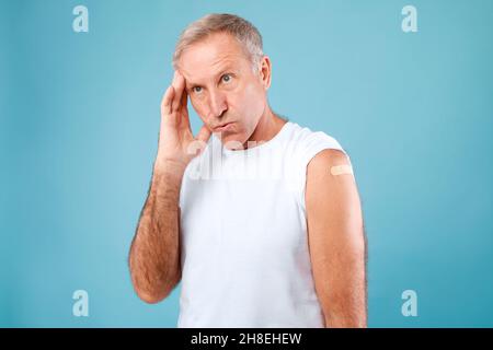 Side Effects To Vaccine. Man With Patch Suffering From Headache Stock Photo