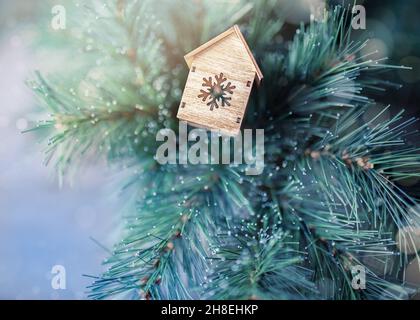Christmas ideas for greeting cards. A little toy house on the fir tree. Stock Photo