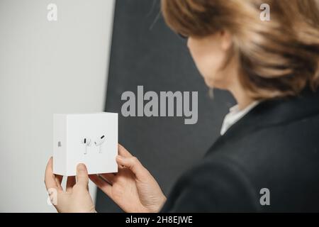 Woman holding before unboxing new AirPods Pro wireless Bluetooth in-ear headphones Stock Photo