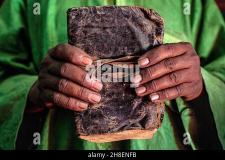 Male hands holding leather bound manuscript book at the private Al-Wangari Library,  in Timbuktu , Mali , Africa . Stock Photo