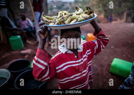 Boy and girl carry  bananas on his head  to the market. Young man sell bananas in the countryside , Mali , West Africa Stock Photo