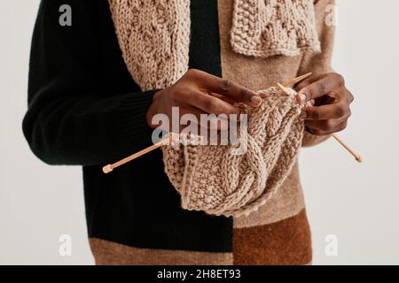 Minimal close up of unrecognizable African-American man knitting scarf, copy space Stock Photo