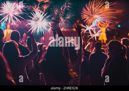 Cheering crowd watching fireworks at New Year Stock Photo