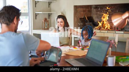 Family working and coloring at dining table Stock Photo