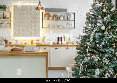 Cozy light kitchen decorated with a Christmas tree. Merry Christmas Stock Photo