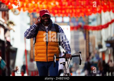 Man with bicycle talking on smart phone in city Stock Photo