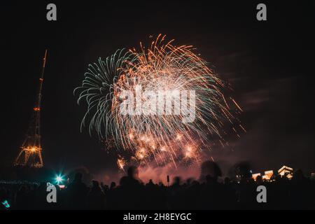 Cheering crowd watching fireworks at New Year Stock Photo