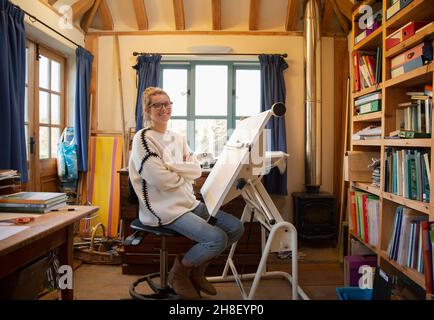 Portrait female architect working at drafting table in home office Stock Photo