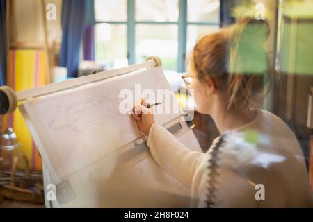 Female architect drafting blueprints in home office Stock Photo