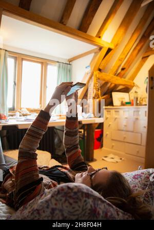 Woman using smart phone at home Stock Photo
