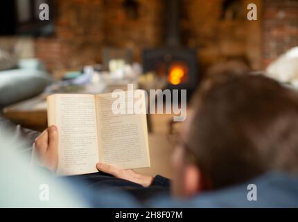 Man reading book in living room Stock Photo
