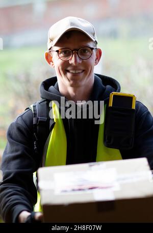 Portrait friendly male courier delivering package Stock Photo