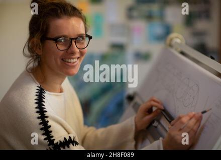 Portrait female architect working at drafting table Stock Photo